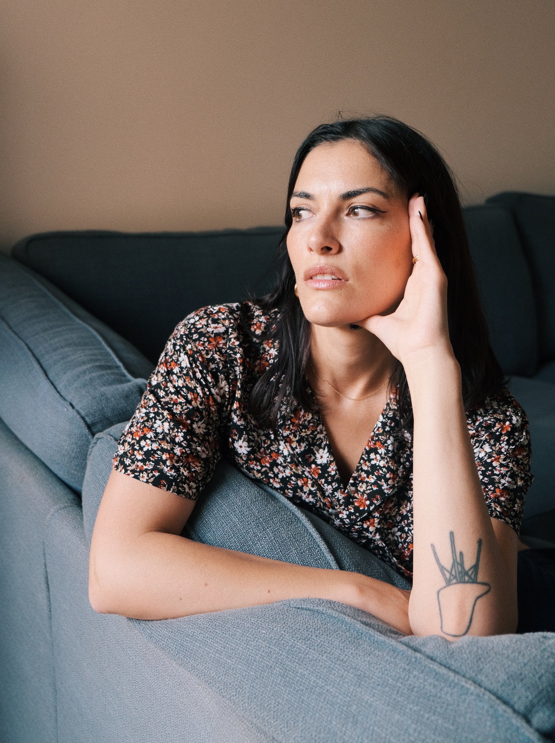 Model wearing the mambo flowers shirt at the sofa