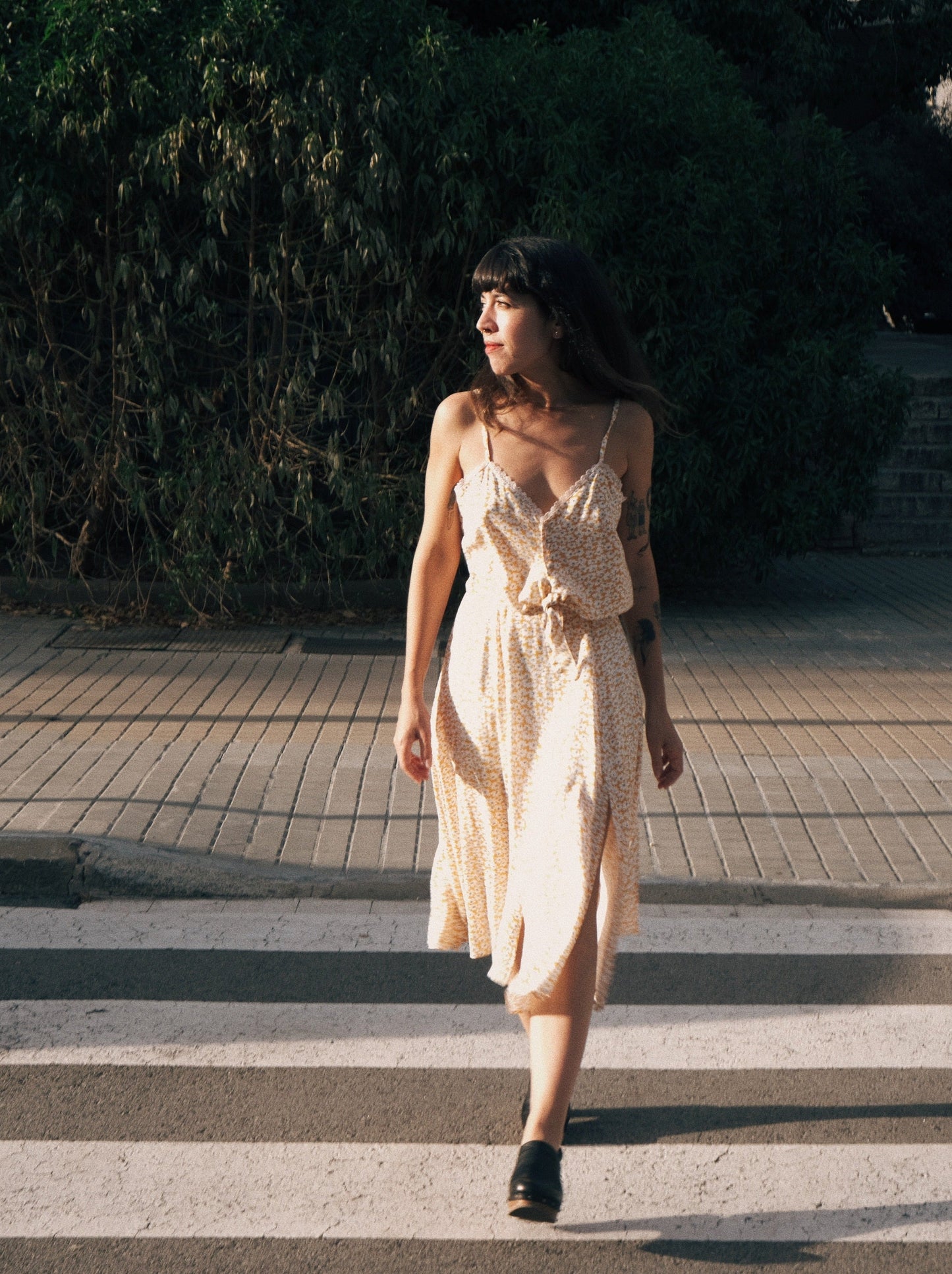 Modelo caminando de frente con conjunto de falda y top fluido estampado de flores. 